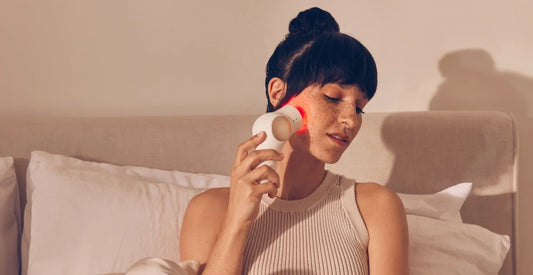 Woman using TheraFace Pro for jaw pain relief at home
